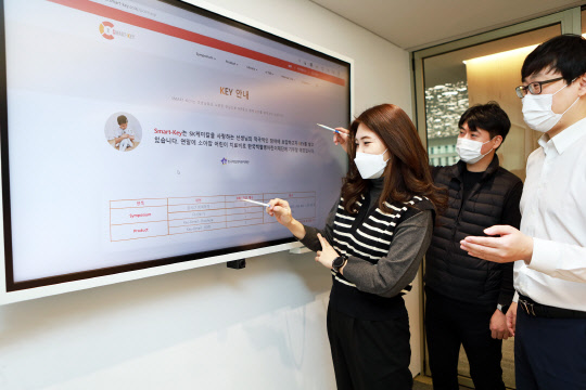 SK케미칼 구성원들이 의료정보 플랫폼 '스마트키'의 콘텐츠를 살펴보고 있다. <SK케미칼 제공>